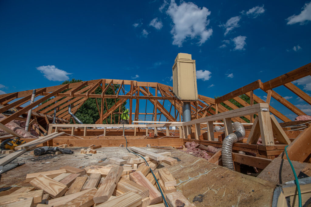 Professional roofers rebuilding roof rafters above a home in North Texas